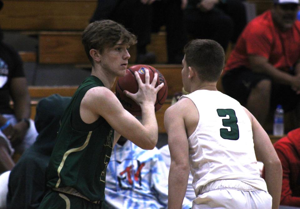 Nease forward Matthew Endicott (left) holds the ball as Fleming Island guard Gavin Goldblatt defends during the 2021 Fortegra High School 9:12 Invitational.