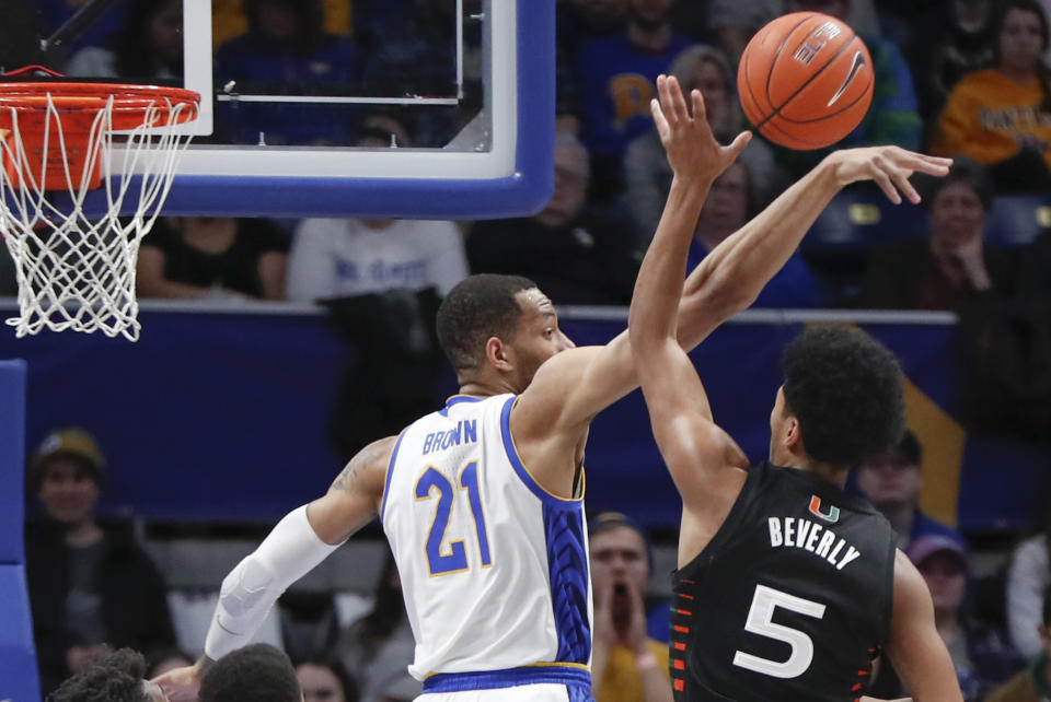 Pittsburgh's Terrell Brown (21) blocks a shot by Miami's Harlond Beverly (5) during the first half of an NCAA college basketball game, Sunday, Feb. 2, 2020, in Pittsburgh. (AP Photo/Keith Srakocic)