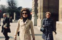 <p>A double-breasted wool camel coat and a black turtleneck—and her signature hairstyle—are Jackie's clothing of choice for a visit to Paris in the late '60s.<br></p>