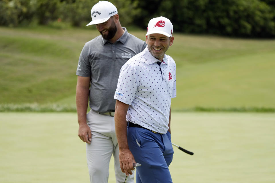Sergio Garcia, right, and Jon Rahm smile on the third green during a practice round of the U.S. Open golf tournament at Los Angeles Country Club, Monday, June 12, 2023, in Los Angeles. (AP Photo/Marcio Jose Sanchez)