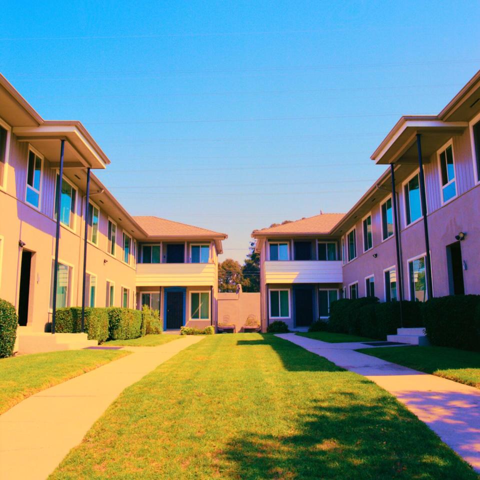 A photo of a courtyard of houses, drenched in sunlight.