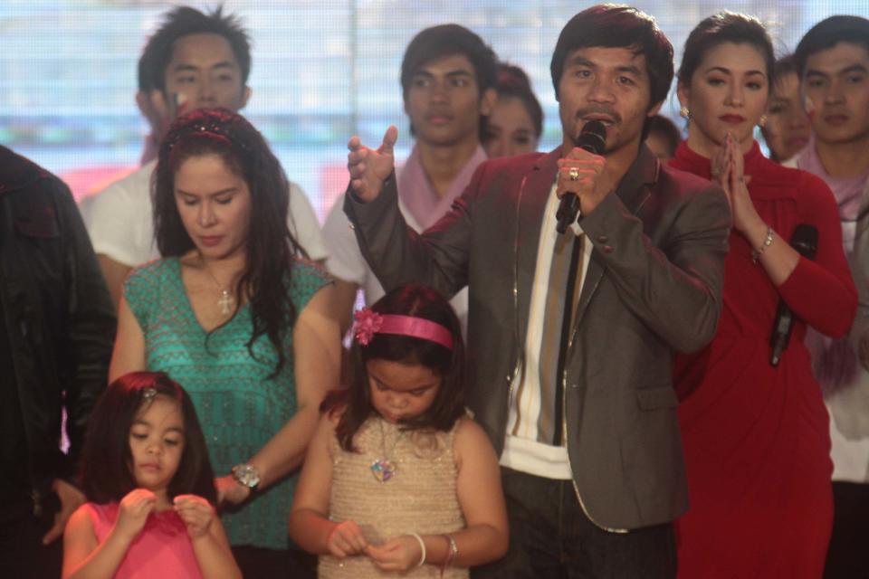Manny Pacquiao stands on stage with his wife Jinkee and kids Princess and Queen Elizabeth. Regine Velasquez is also on stage with other Kapuso talents. (George Calvelo/NPPA Images)
