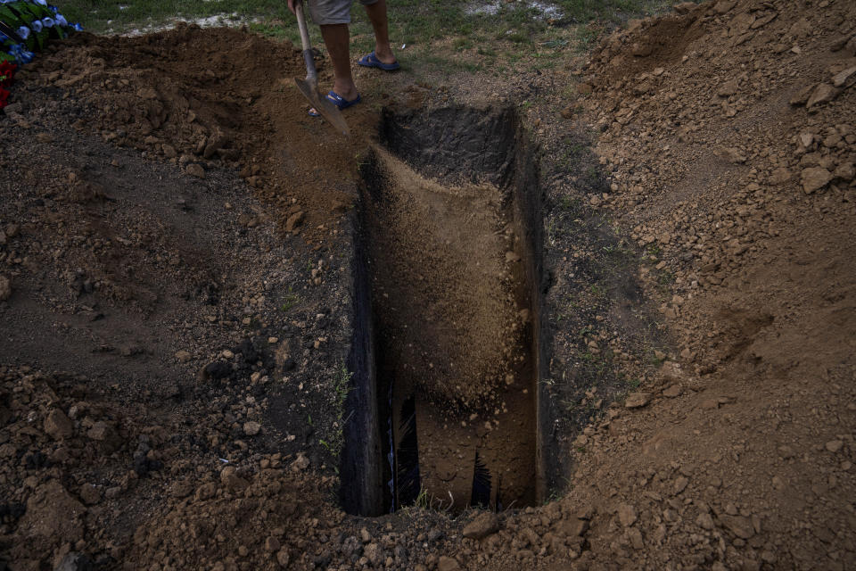 FILE A grave digger uses his shovel to throw dirt on the coffin of 40-year-old Volodymyr Miroshnychenko who was killed on the frontlines of Marinka, during his funeral procession at a cemetery in Pokrovsk, eastern Ukraine, Friday, July 15, 2022. Ukrainians living in the path of Russia's invasion in the besieged eastern Donetsk region are bracing themselves for the possibility that they will have to evacuate. The mayor of Pokrovsk is mentally preparing for a military-ordered evacuation in which he would be among the last to leave. (AP Photo/Nariman El-Mofty, File)