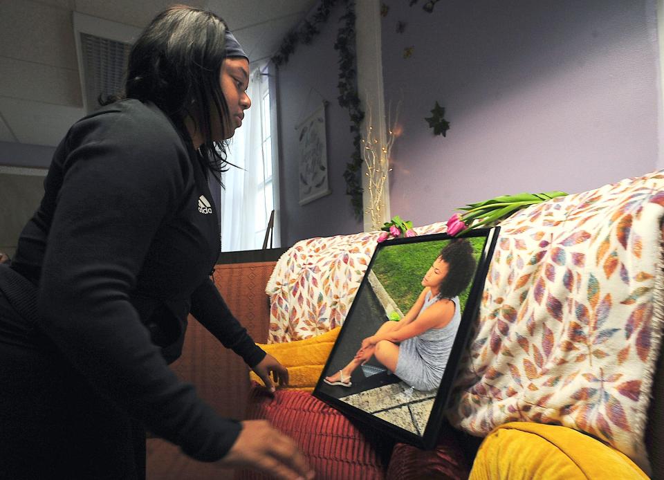 Monique Broadus, a former staffer at the Robert W. Johnson Community Center, looks at a picture of Ty'kerria Dawson in the center's library. Broadus said Ty'kerria was always easy to pick out among others in the Jonathan Street neighborhood because of her walk and beautiful smile.