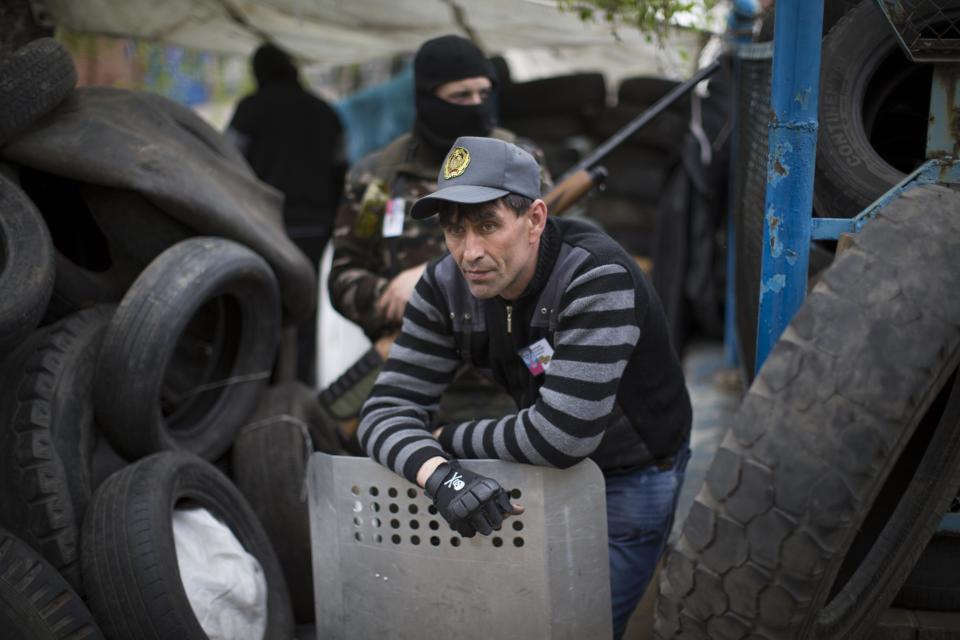 Pro-Russian activists guard barricades in Slovyansk, Ukraine, Saturday, April 19, 2014. Pro-Russian insurgents defiantly refused Friday to surrender their weapons or give up government buildings in eastern Ukraine, despite a diplomatic accord reached in Geneva and overtures from the government in Kiev.(AP Photo/Alexander Zemlianichenko)