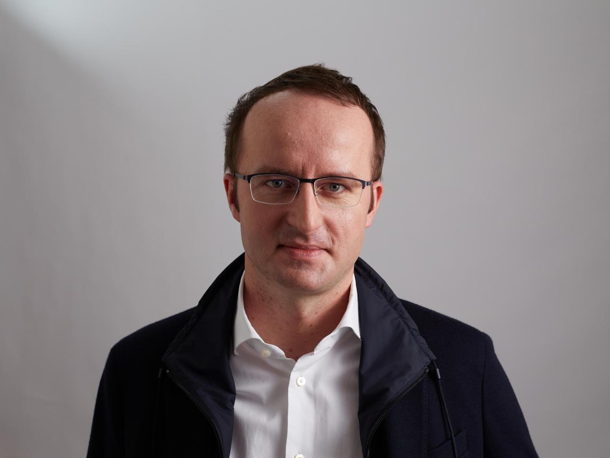 A headshot of Crypto.com CEO Kris Marszalek in white shirt and a black jacket