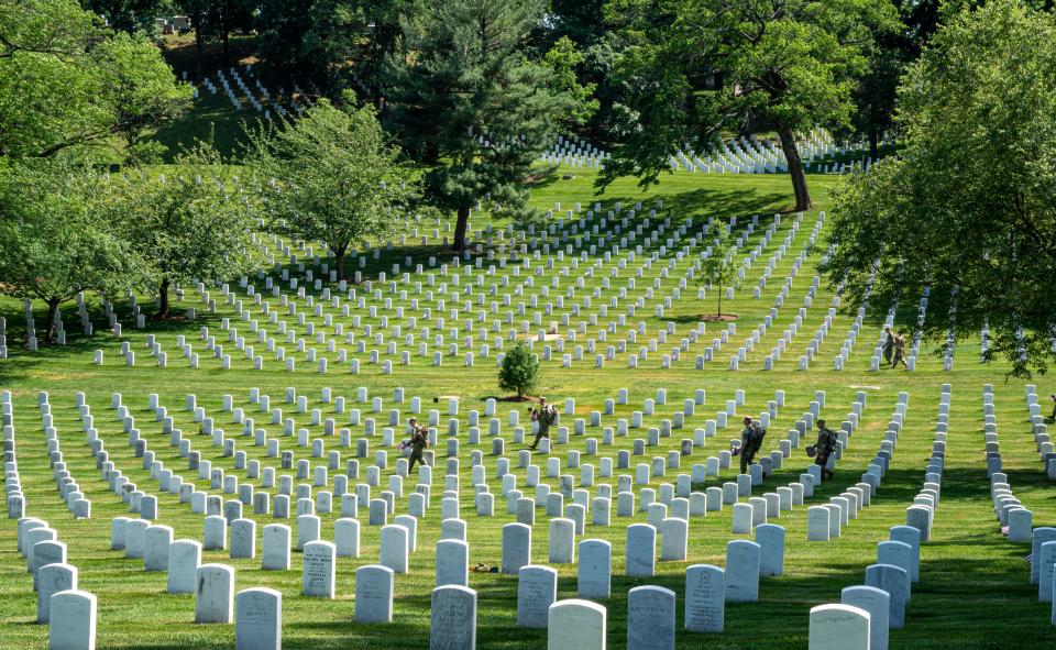 Members of the 3rd United States Infantry Regiment, also known as The Old Guard, place flags in front of each headstone as part of the "Flags In" ceremony at Arlington National Cemetery in Arlington, Va. on Thursday, May 27, 2021. Since 1948, The Old Guard has placed flags at each headstone in honor of Memorial Day.