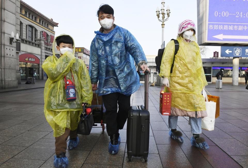 Passengers wear masks and raincoats at Beijing Station on Feb. 10, 2020, amid the spread of the new coronavirus. Source: AAP