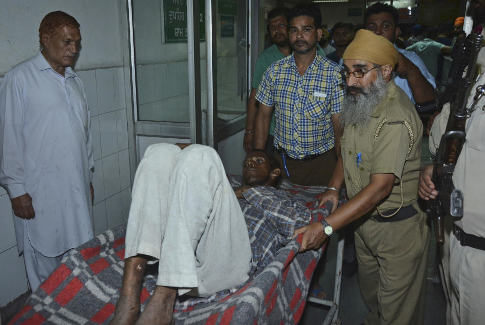 A man who got injured in a train accident is brought for treatment to a hospital in Amritsar, India, Friday, Oct. 19, 2018. A speeding train ran over a crowd watching fireworks during a religious festival in northern India on Friday, killing at least 50 people, a Congress party leader said. (AP Photo/Prabhjot Gill)