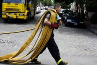 Un bombero lleva mangueras para combatir un incendio en la empresa Iron Mountain en que se habían registrado nueve muertos, incluso bomberos, en Buenos Aires, Argentina, el miércoles 5 de febrero de 2014. (AP Photo/Rodrigo Abd)