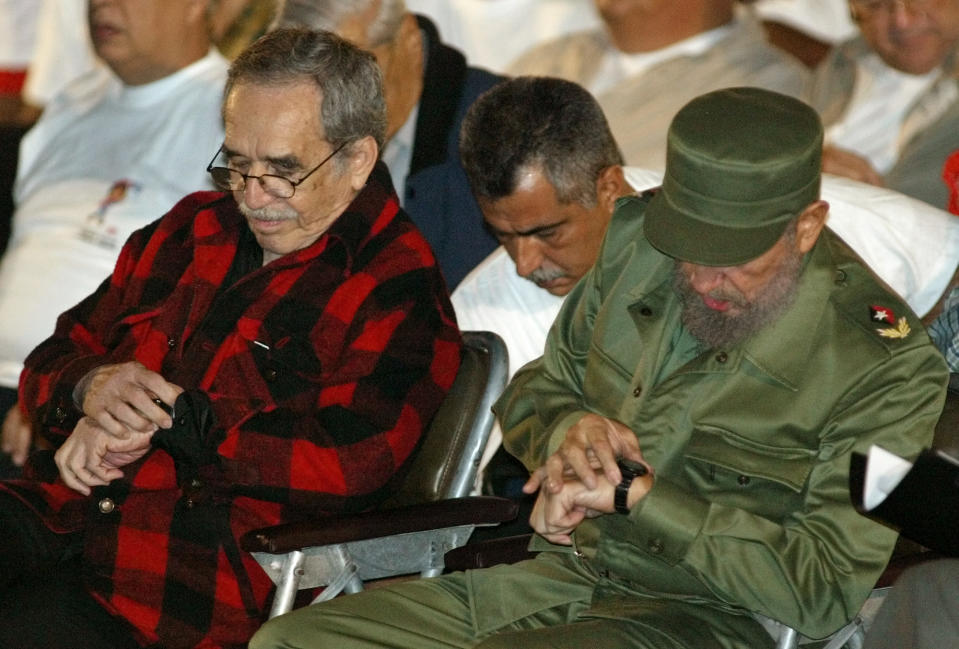 FILE - In this Nov. 26, 2002 file photo, Cuba's leader Fidel Castro, right, and Colombian Nobel laureate Gabriel Garcia Marquez check their watches during the inauguration of the first Cuban National Olympic games at Revolution Square in Havana, Cuba. Marquez died Thursday April 17, 2014 at his home in Mexico City.(AP Photo/Jose Goitia, File)
