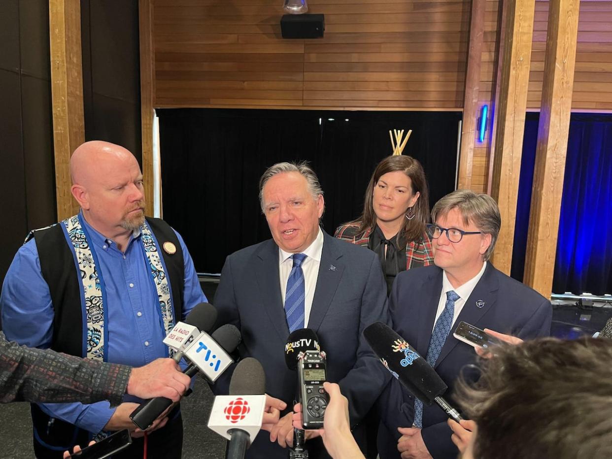 Premier François Legault spoke to reporters following the signing of a framework agreement with the Innu nation of Pessamit. He was joined by Quebec's Indigenous affairs minister, Ian Lafrenière (left), CAQ MNAs Yves Montigny (right) and Katéri Champagne-Jourdain.  (Renaud Chicoine-Mckenzie/Radio-Canada - image credit)