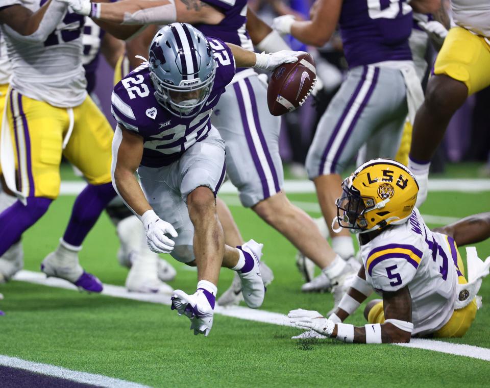 Kansas State running back Deuce Vaughn crosses the goal line to score a touchdown as LSU safety Jay Ward tries to make the tackle during the second quarter of the Texas Bowl.