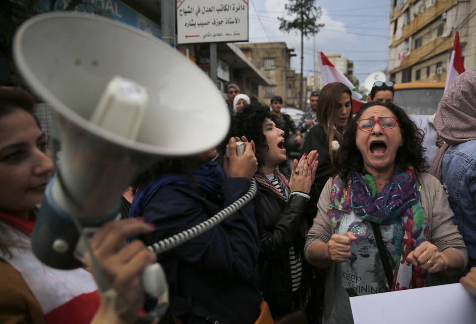 Lebanese women shout slogans during a protest against the return of the civil war, in Beirut, Lebanon, Wednesday, Nov. 27, 2019. Hundreds of Lebanese women marched across a former front line in the Lebanese capital carrying white roses and Lebanese flags to denounce overnight clashes between rival groups that injured dozens of people. (AP Photo/Hussein Malla)