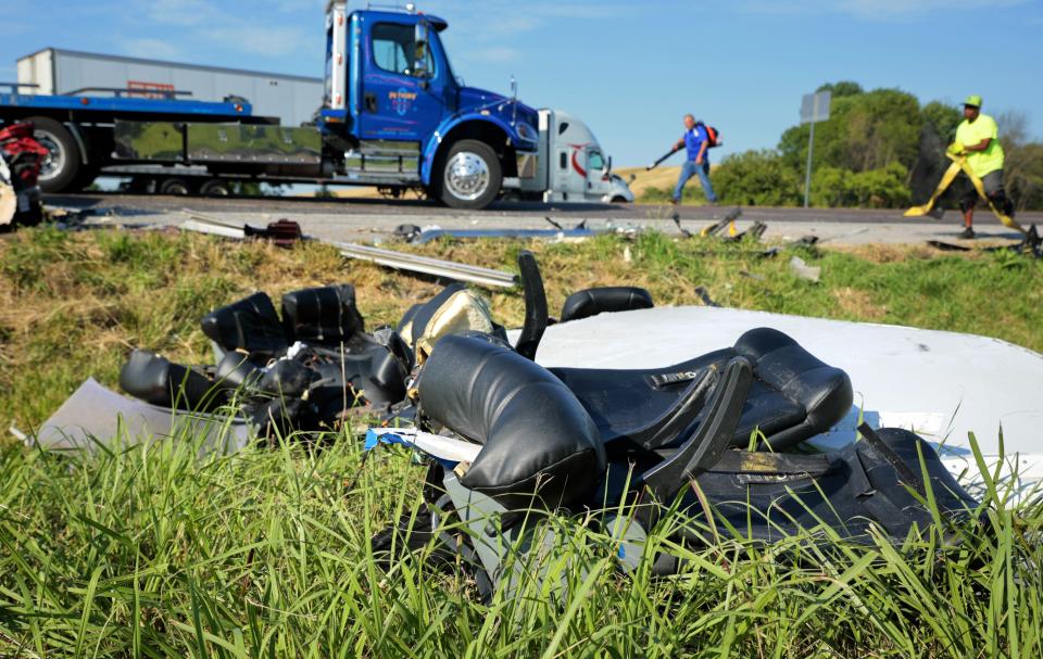 Workers clear debris from westbound Interstate 70 on Wednesday, July 12, 2023, after a Greyhound passenger bus collided with a tractor-trailer near Highland, Ill. (Christian Gooden/St. Louis Post-Dispatch via AP)