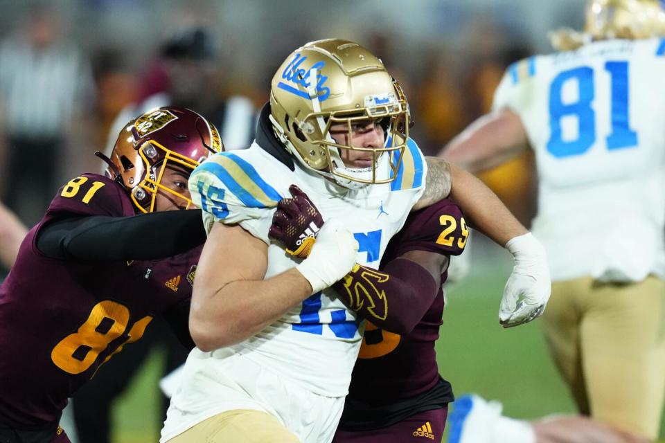 UCLA linebacker Laiatu Latu gets double-teamed during a game against Arizona State in November.