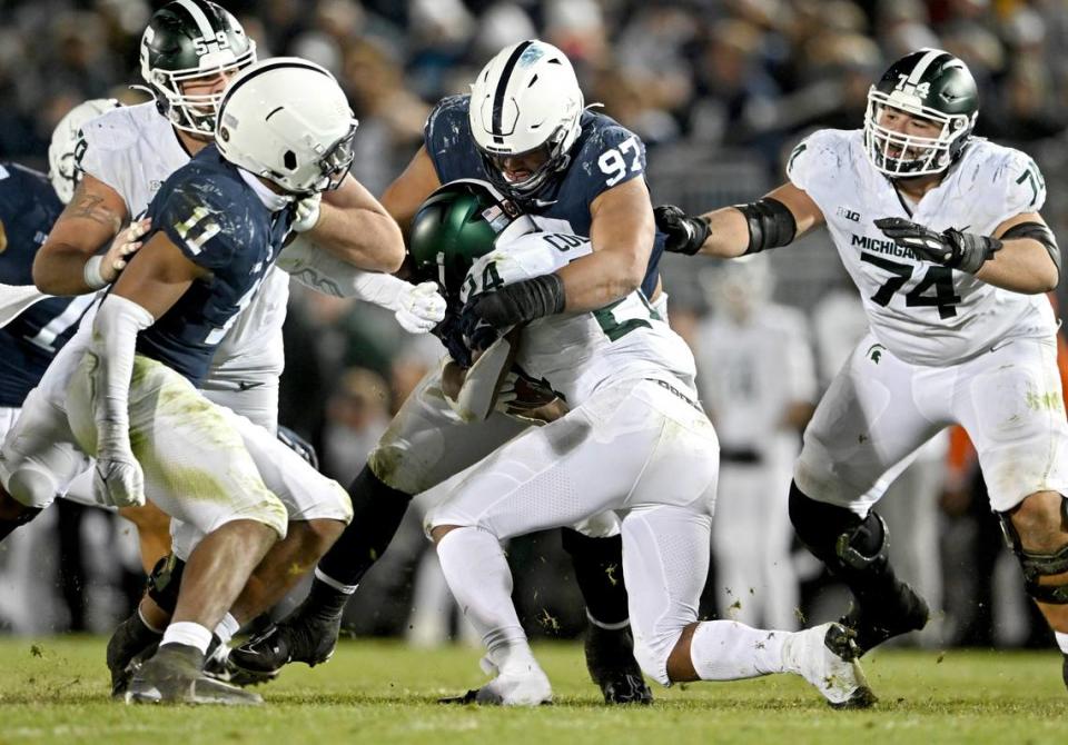 Penn State defensive tackle PJ Mustipher stoops Michigan State’s Elijah Collins during the game on Saturday, Nov. 26, 2022.