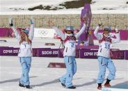 Norway's Therese Johaug, Marit Bjoergen and Kristin Stoermer Steira (L-R) celebrate during the flower ceremony for the women's cross-country 30 km mass start free event at the Sochi 2014 Winter Olympic Games February 22, 2014. REUTERS/Stefan Wermuth