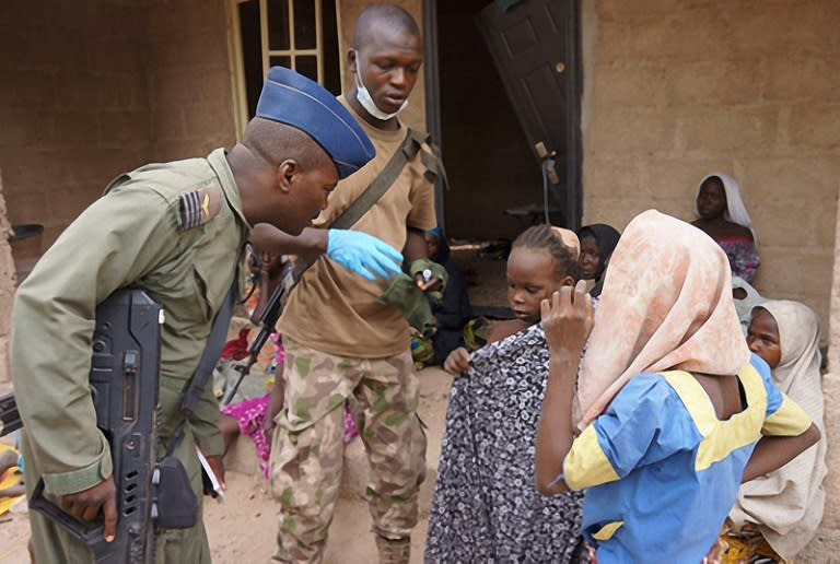 Picture released by the Nigerian army on April 30, 2015 and taken at an undisclosed location shows a member of the Nigerian Army standing next to a group of girls rescued in an operation against the Islamist group Boko Haram