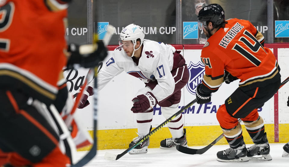 Colorado Avalanche center Tyson Jost, back left, reaches out to control the puck as Anaheim Ducks center Adam Henrique defends in the first period of an NHL hockey game Friday, March 5, 2021, in Denver. (AP Photo/David Zalubowski)