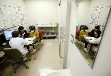 Dang Nguyen Thuc Vien (back L), a 32-year-old daughter of refugees from south Vietnam, acts as an interpreter to help a local Vietnamese resident in Japan at a hospital in Kanagawa prefecture, south of Tokyo, Japan, November 25, 2015. REUTERS/Yuya Shino