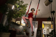 Trapeze artist Regina Oliveira performs her clown act for live, online streaming of the "Benditas Genis" women's clown festival at her home during the COVID-19 pandemic in Rio de Janeiro, Brazil, Sunday, March 14, 2021. Oliveira transformed her apartment in the hilltop Santa Teresa neighborhood into a small studio, complete with professional lighting and trapeze, to give classes and presentations. (AP Photo/Bruna Prado)