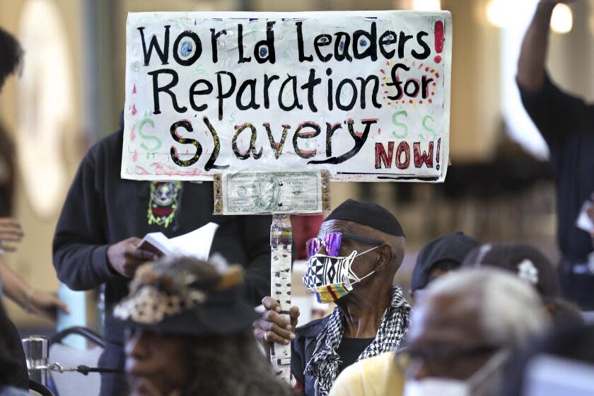 Los Angeles, California-Sept. 22, 2022-Los Angeles long-time resident, Walter Foster, age 80, holds up a sign as the Reparations Task Force meets to hear public input on reparations at the California Science Center in Los Angeles on Sept. 22, 2022. (Carolyn Cole / Los Angeles Times)