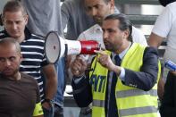 Ahmed Senbel, head of the Federation Nationale des Taxis Independants union (FNTI), speaks to striking taxi drivers who gather near the Paris ring road during a national protest against car-sharing service Uber, in Paris, France, June 25, 2015. (REUTERS/Charles Platiau)