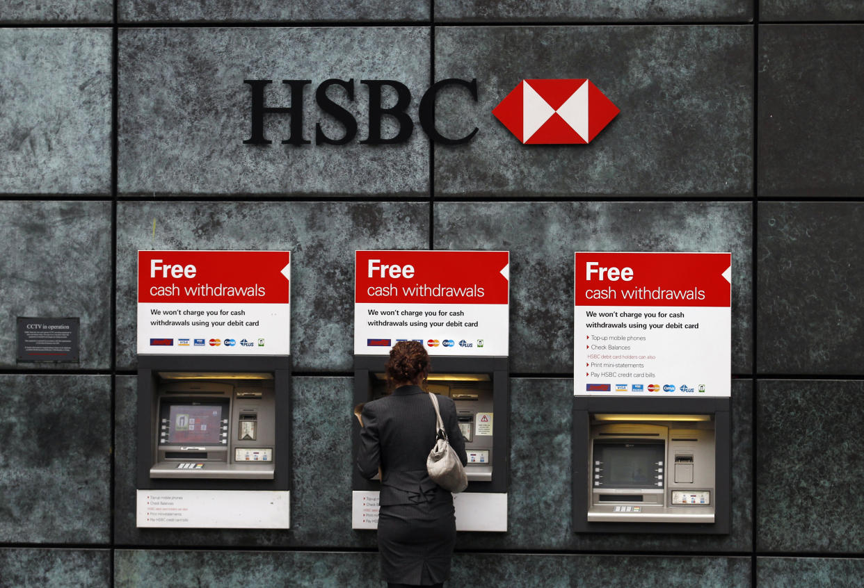 A woman uses a cash point machine at a HSBC bank in the City of London February 28, 2011. HSBC cut its profitability targets due to the cost of tougher banking regulations, joining rivals such as Barclays, and disappointed investors with below forecast 2010 earnings.    REUTERS/Andrew Winning (BUSINESS)