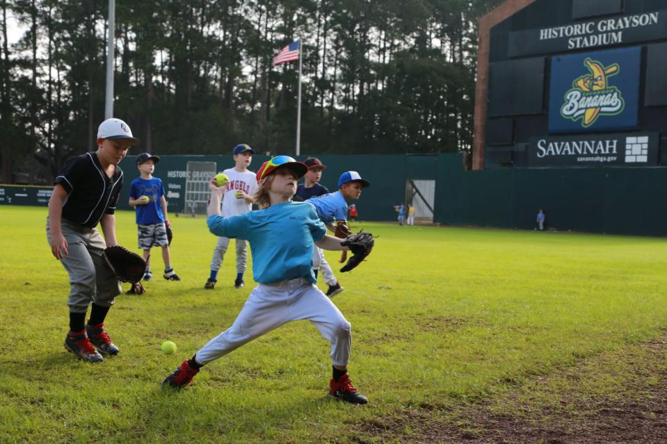 Campers throw at a square on the outfield wall as they run drills Tuesday during a Savannah Bananas baseball camp at Grayson Stadium.