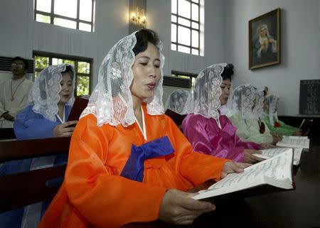 North Koreans read mass at a Catholic church in Pyongyang in this August 17, 2003 file photo. REUTERS/Lee Jae-won/Files