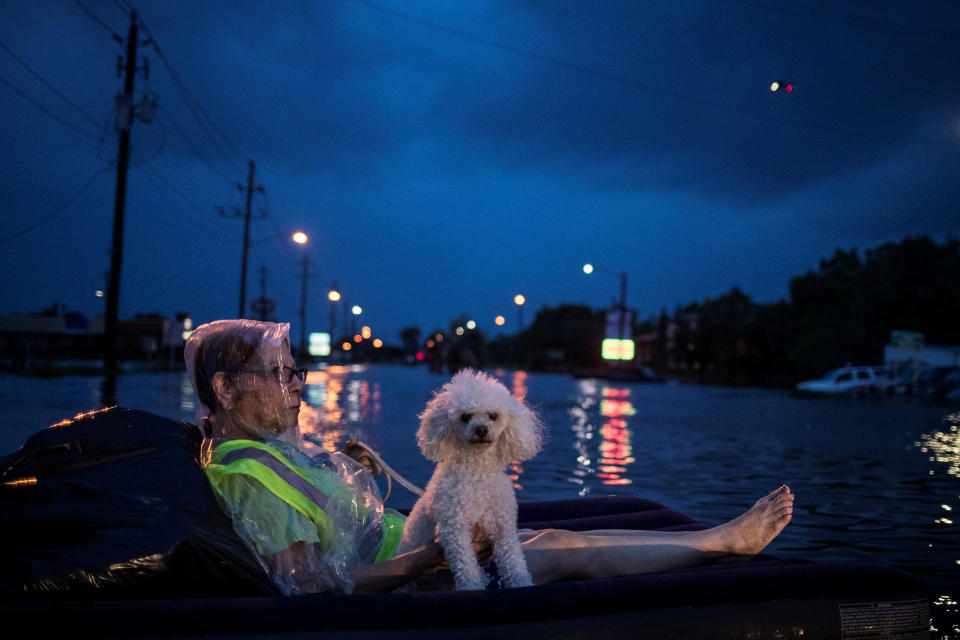 <p>A rescue helicopter hovers in the background as an elderly woman and her poodle use an air mattress to float above flood waters from Tropical Storm Harvey while waiting to be rescued from Scarsdale Boulevard in Houston, Texas, Aug. 27, 2017. (Photo: Adrees Latif/Reuters) </p>