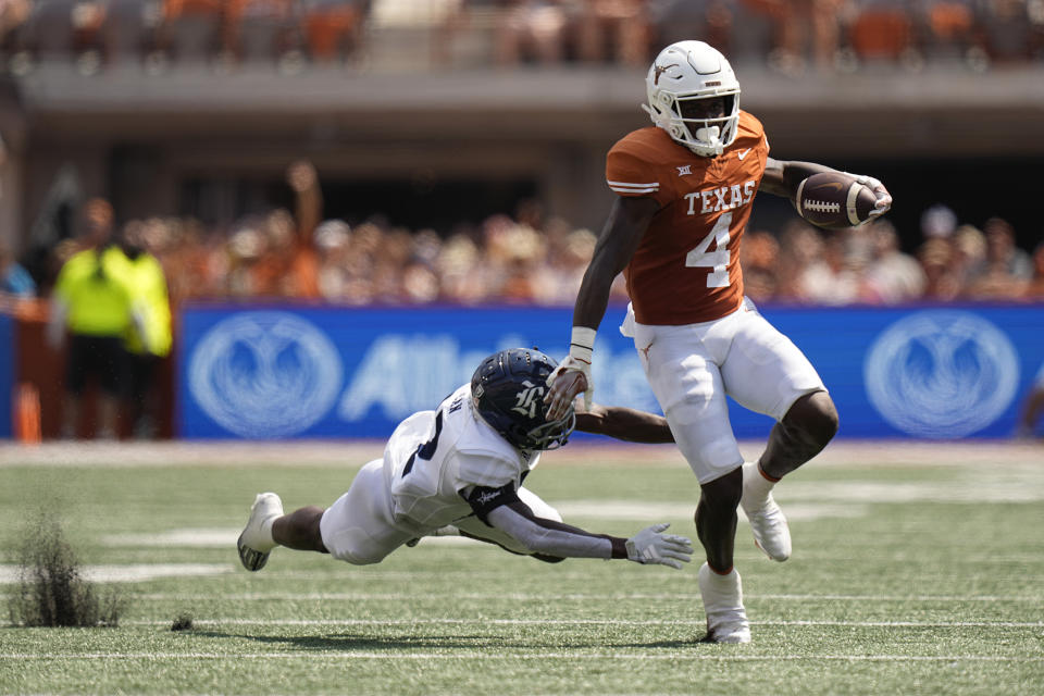 Texas running back CJ Baxter Jr. (4) runs past Rice cornerback Jonathan Jean, left, during the first half of an NCAA college football game in Austin, Texas, Saturday, Sept. 2, 2023. (AP Photo/Eric Gay)