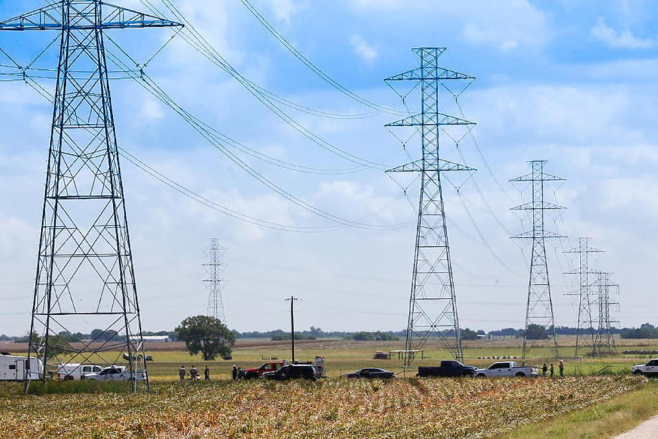 <p>Investigators surround the scene in a field near Lockhart, Texas where a hot air balloon carrying at least 16 people collided with power lines, July 30, 2016. (Ralph Barrera/Austin American-Statesman via AP)</p>