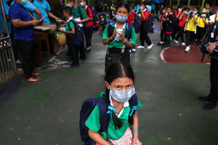 Students wear masks as they wait to be picked up, as classes in over 400 Bangkok schools have been cancelled due to worsening air pollution, at a public school in Bangkok, Thailand, January 30, 2019. REUTERS/Athit Perawongmetha