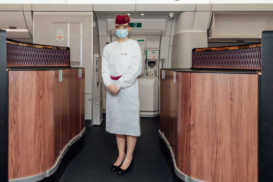 Qatar air hostess Braydin poses in full PPE on board flight