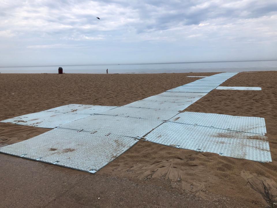 A beach mat at Indiana Dunes State Park makes it possible for wheelchairs to roll close to the edge of Lake Michigan.