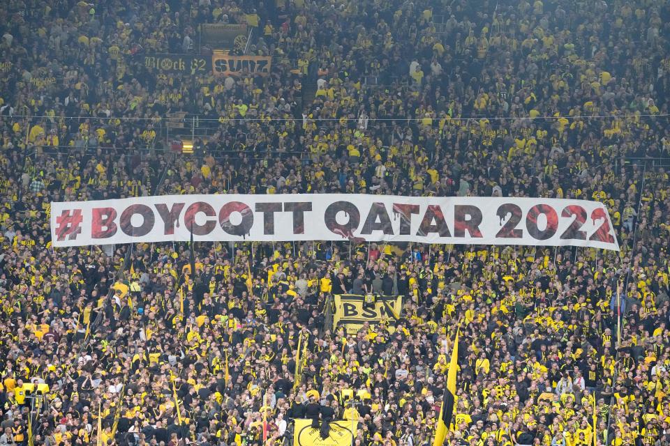 Fans display a banner during the German Bundesliga soccer match between Borussia Dortmund and VfB Stuttgart in Dortmund, Germany, Saturday, Oct. 22, 2022. Normally when the World Cup comes around, Germans proudly fly their country's flag and enthusiastically back their team. Not this time. People boycotting the tournament and many fans say they won't watch in protest against human rights abuses in Qatar.