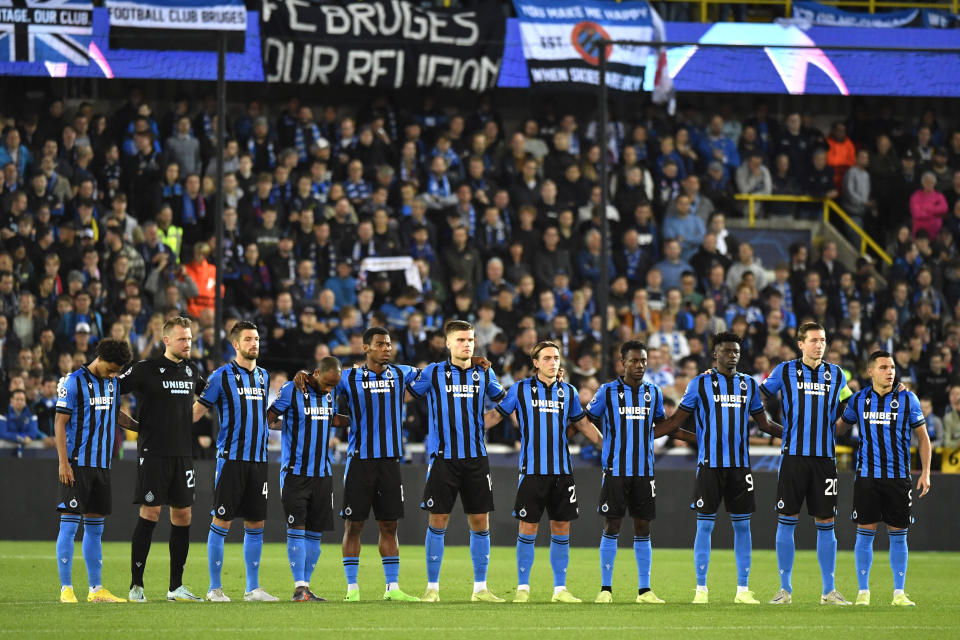 Players of Club Brugge stand for a moment of silence to remember the victims of the Indonesia stadium tragedy prior to the Champions League Group B soccer match between Club Brugge and Atletico Madrid at the Jan Breydel stadium in Bruges, Belgium, Tuesday, Oct. 4, 2022. (AP Photo/Geert Vanden Wijngaert)