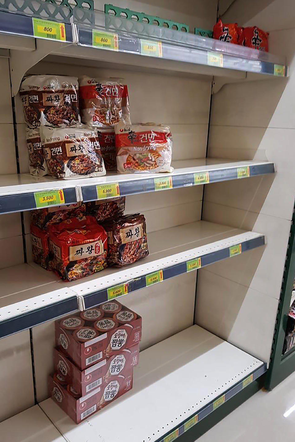 FILE - In this Feb. 21, 2020 file photo, Packages of instant noodles are displayed on almost empty shelves at a supermarket in Daegu, South Korea. As fears of a soaring viral outbreak grip the southeastern South Korean city of Daegu and nearby areas, many residents are struggling as they try to avoid the new virus. (AP Photo/Noh Yeo Jin, File)