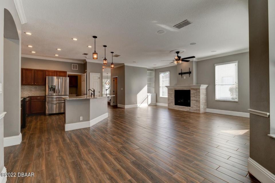 The updated kitchen looks out over the great room, featuring wood-look tile floors, crown molding and a gas fireplace.