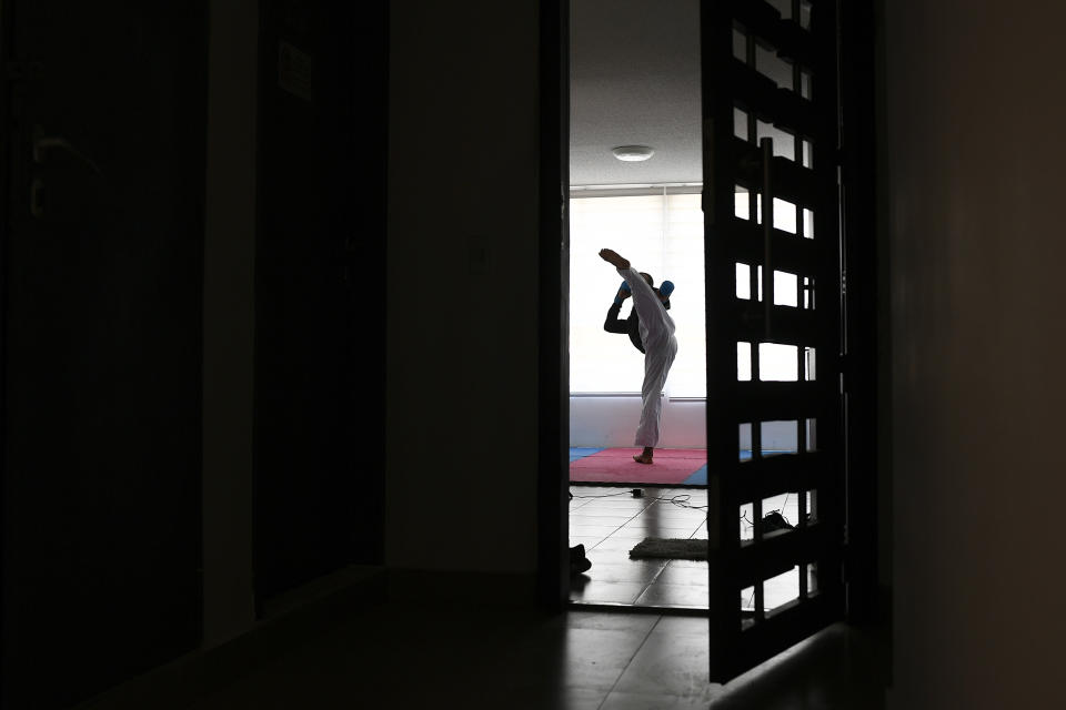 El karateca venezolano Andrés Madera, medallista de oro en los Juegos Panamericanos de Lima 2018, entrena en solitario dentro de su apartamento en Caracas, el jueves 30 de abril de 2020 (AP Foto/Matías Delacroix)