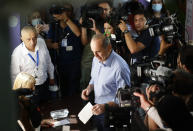 Former Armenian President Robert Kocharyan, center, casts his ballot at a polling station during a parliamentary election in Yerevan, Armenia, Sunday, June 20, 2021. Armenians are voting in a national election after months of tensions over last year's defeat in fighting against Azerbaijan over the separatist region of Nagorno-Karabakh. (AP Photo/Sergei Grits)