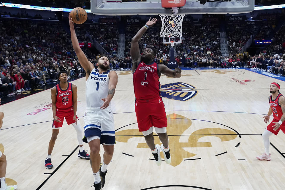 Minnesota Timberwolves forward Kyle Anderson (1) goes to the basket against New Orleans Pelicans forward Zion Williamson (1) in the first half of an NBA basketball game in New Orleans, Monday, Dec. 11, 2023. (AP Photo/Gerald Herbert)