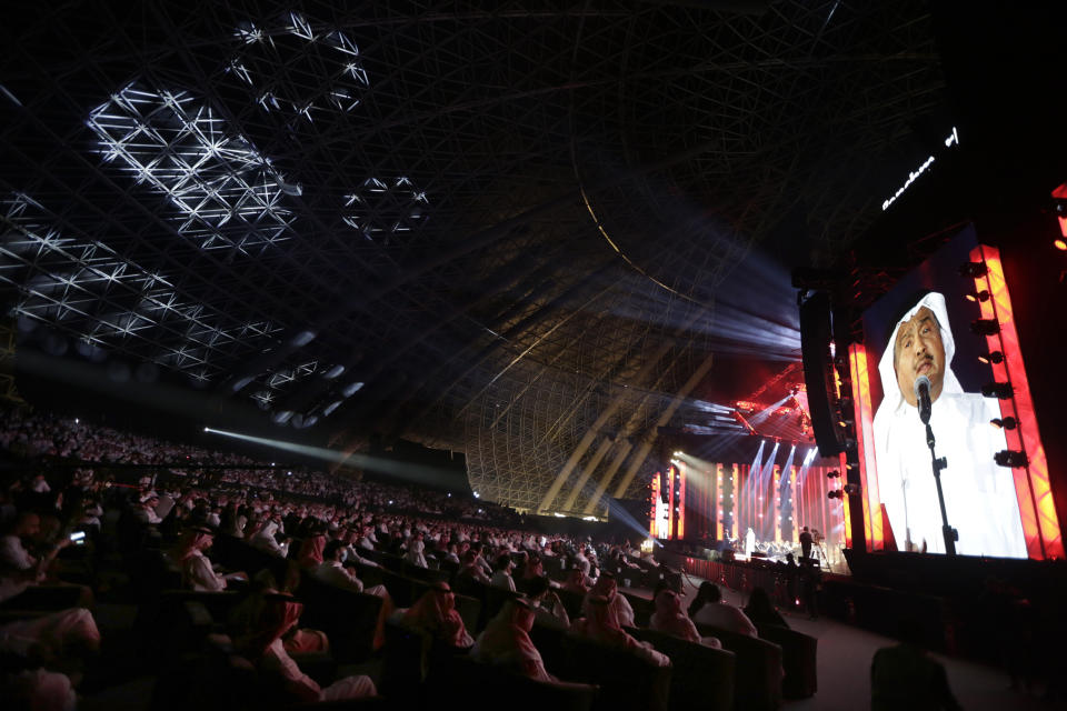 In this July 8, 2021 photo, audience members cheer as Saudi prominent singer Mohammed Abdu, viewed on the screen, performs onstage at the newly built Super Dome, in Jiddah, Saudi Arabia. The cloud of social restrictions that loomed over generations of Saudis is quickly dissipating and the country is undergoing visible change. Still, for countless numbers of people in the United States and beyond, Saudi Arabia will forever be associated with 9/11. (AP Photo/Amr Nabil)