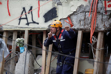 A paramedic gestures during a search for students at the Enrique Rebsamen school after an earthquake in Mexico City, Mexico September 21, 2017. REUTERS/Jose Luis Gonzalez