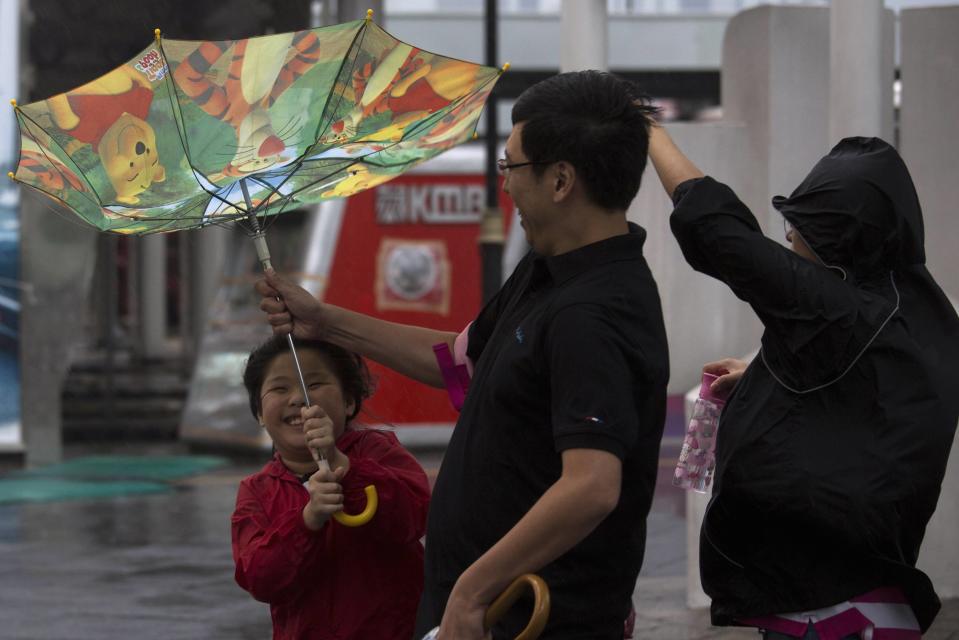 A child holds an inside-out umbrella broken due to strong winds before Typhoon Usagi is expected to make landfall, in Hong Kong September 22, 2013. Hong Kong was bracing on Sunday for this year's most powerful typhoon, with government meteorologists warning of severe flooding created by a double whammy of powerful winds and exceptionally high tides. REUTERS/Tyrone Siu (CHINA - Tags: ENVIRONMENT DISASTER SOCIETY)