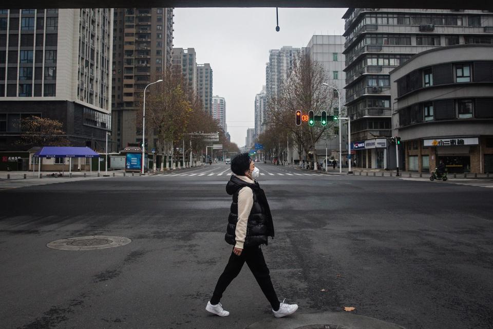 A woman walks on an empty road on January 27, 2020 in Wuhan, China. As the death toll from the coronavirus reaches 80 in China with over 2700 confirmed cases, the city remains on lockdown for a fourth day.