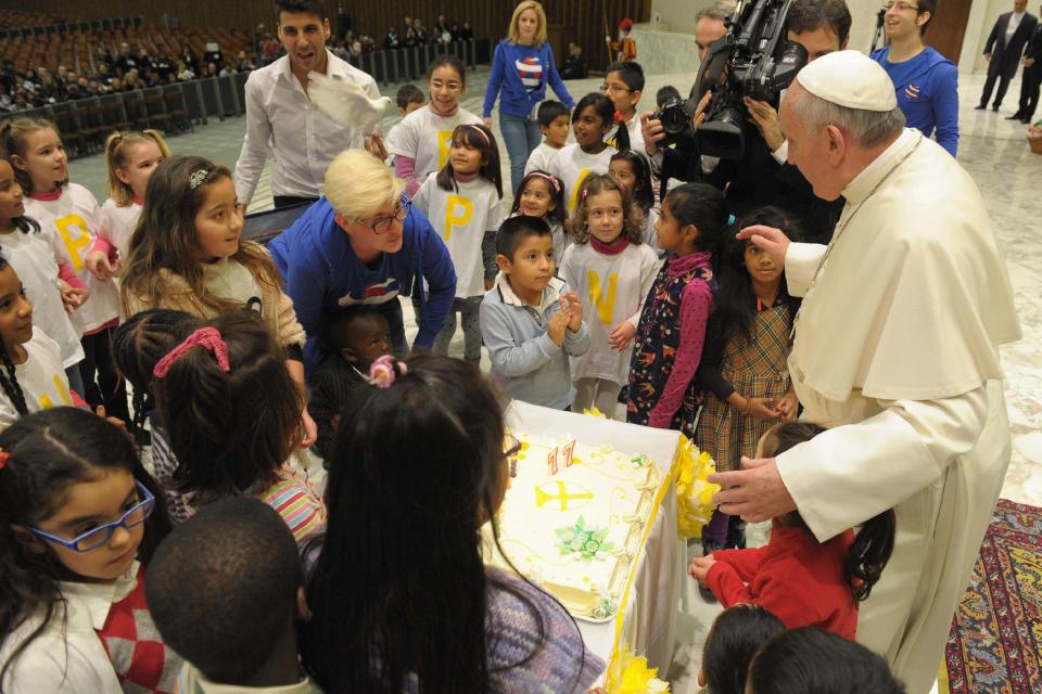 Pope Francis blows a candle on a cake presented to him during an audience with children assisted by volunteers of Santa Marta institute in Paul VI hall at the Vatican December 14, 2013. Pope Francis, who will celebrate his 77th birthday on December 17, 2013, has received the cake three days in advance. REUTERS/Osservatore Romano (VATICAN - Tags: RELIGION POLITICS) ATTENTION EDITORS - THIS IMAGE WAS PROVIDED BY A THIRD PARTY. FOR EDITORIAL USE ONLY. NOT FOR SALE FOR MARKETING OR ADVERTISING CAMPAIGNS. NO SALES. NO ARCHIVES. THIS PICTURE IS DISTRIBUTED EXACTLY AS RECEIVED BY REUTERS, AS A SERVICE TO CLIENTS