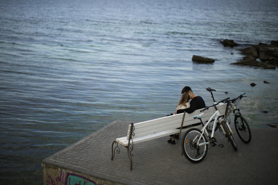 A couple sit on a bench in Odesa, Ukraine, Tuesday, May 17, 2022. (AP Photo/Francisco Seco)